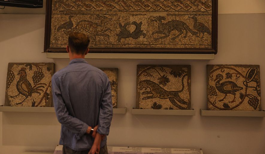 A visitor looks at ancient mosaics on display at the National Museum of Syria in Damascus, Friday, May 23, 2025. (AP Photo/Ghaith Alsayed)