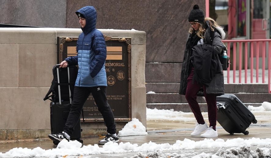 Pedestrians walk on the sidewalk during a cold day in Chicago, Tuesday, Nov. 11, 2025. (AP Photo/Nam Y. Huh)