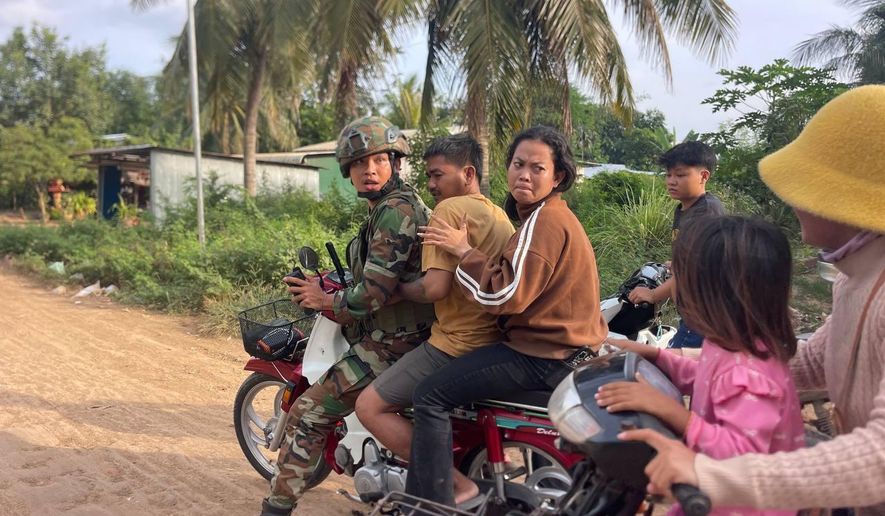 In this photo released by Agence Kampuchea Press (AKP), an injured man, second from right, is picked up by a Cambodian army soldier on a motorbike after Thai soldiers opened fire on civilians in Prey Chan village, Banteay Meanchey province, on the border with Thailand, Wednesday, Nov. 12, 2025. (AKP via AP)