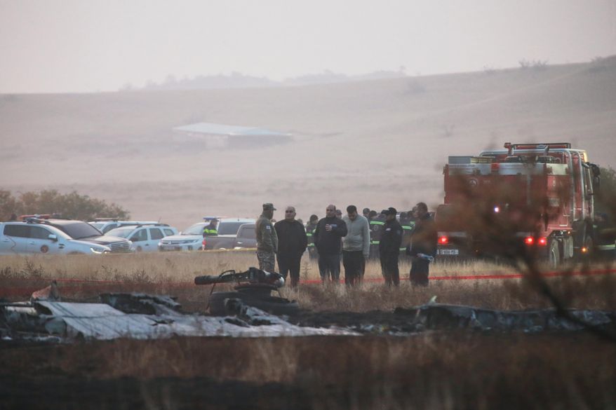 Investigators stand next to debris at a crash site of a Turkish military cargo plane in Georgia's Sighnaghi municipality, close to the Azerbaijani border on Wednesday, Nov. 12, 2025. (AP Photo/Zurab Tsertsvadze)