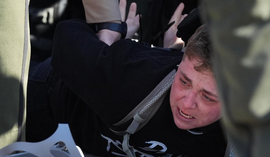 Illinois State police detain a protester outside an ICE processing facility in the Chicago suburb of Broadview, Ill., Friday, Nov. 14, 2025. (AP Photo/Nam Y. Huh)