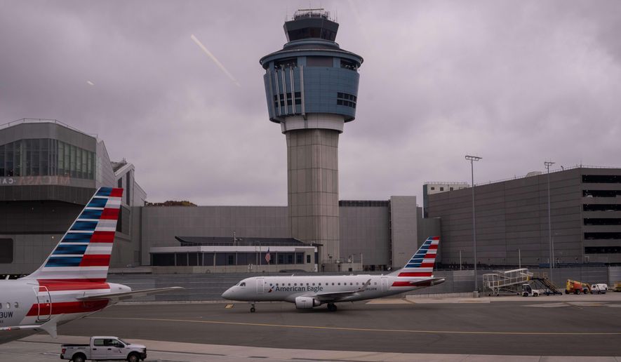An American Eagle plane moves past the FAA Air Traffic Control tower at LaGuardia Airport (LGA) in the Queens borough of New York, Sunday, Nov. 9, 2025. (AP Photo/Adam Gray)