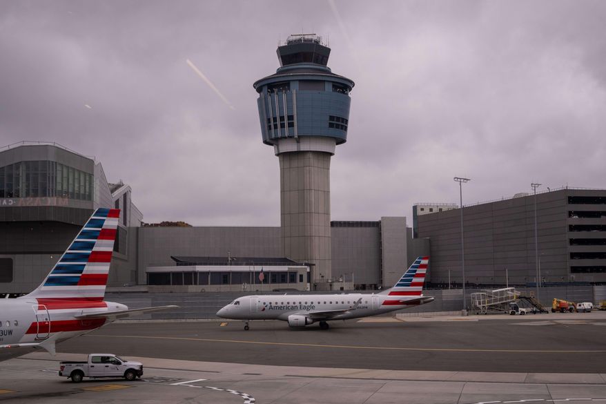 An American Eagle plane moves past the FAA Air Traffic Control tower at LaGuardia Airport (LGA) in the Queens borough of New York, Sunday, Nov. 9, 2025. (AP Photo/Adam Gray)