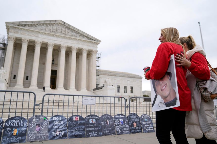Jen Trejo holds a photo of her son Christopher as she is comforted outside the Supreme Court Dec. 4, 2023, in Washington. (AP Photo/Stephanie Scarbrough, File)