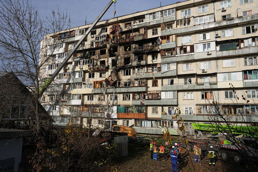 Rescuers work on the scene of a building damaged after a Russian attack in Kyiv, Ukraine, on Friday, Nov. 14, 2025. (AP Photo/Efrem Lukatsky)