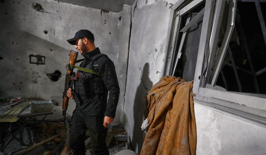 A Syrian Internal Security Forces officer inspects a home in Damascus, Syria, Friday, Nov. 14, 2025, after it was hit by rockets, according to state media. It was not immediately clear who was behind the attack. (AP Photo/Omar Sanadiki)