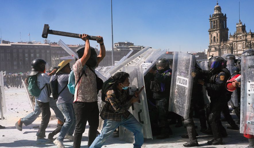Protesters charge at police during a youth anti-government march in Mexico City, Saturday, Nov. 15, 2025. (AP Photo/Marco Ugarte)