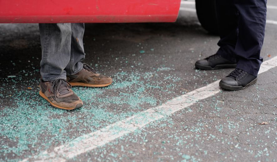 Willy Aceituno, left, makes a police report with Charlotte-Mecklenburg Police Department officer N. Sherill, after U.S. Customs and Border Protection officers broke his window during an enforcement operation, Saturday, Nov. 15, 2025, in Charlotte, N.C. (AP Photo/Erik Verduzco)
