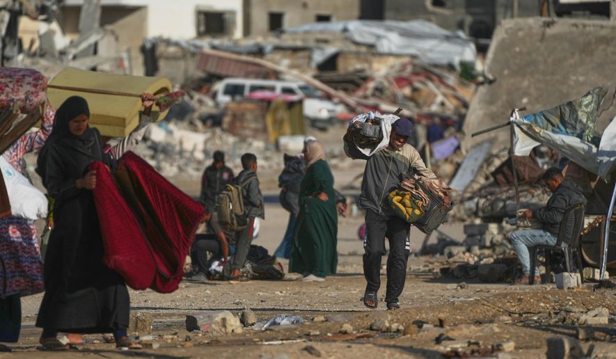 A man Palestinian man carries bags of firewood after collecting them from the rubbish in Khan Younis, southern Gaza Strip, on Saturday, Nov. 15, 2025.(AP Photo/Abdel Kareem Hana)