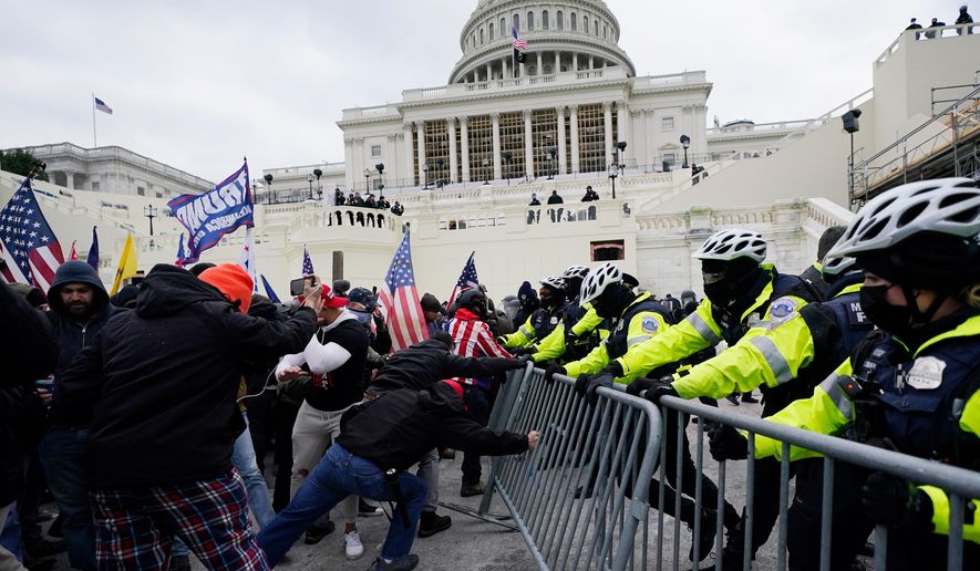 Violent insurrections loyal to President Donald Trump break through a police barrier at the Capitol in Washington on Jan. 6, 2021. (AP Photo/Julio Cortez, File)