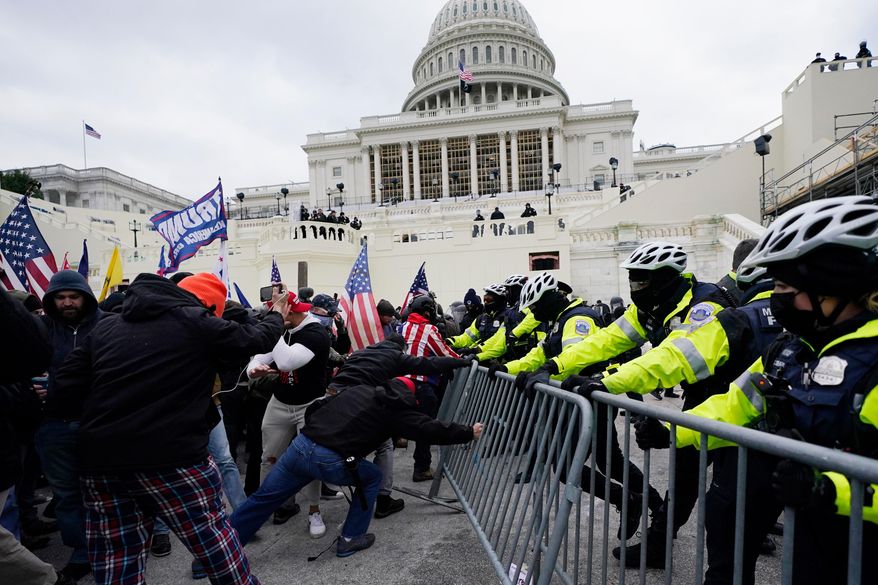 Violent insurrections loyal to President Donald Trump break through a police barrier at the Capitol in Washington on Jan. 6, 2021. (AP Photo/Julio Cortez, File)