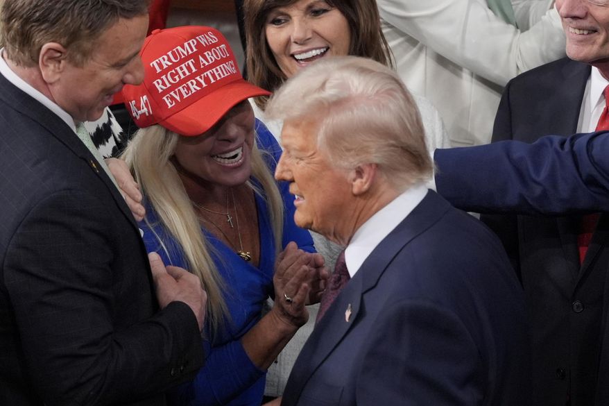 FILE - President Donald Trump arrives and walks by Rep. Marjorie Taylor Greene, R-Ga., to address a joint session of Congress at the Capitol in Washington, Tuesday, March 4, 2025. (AP Photo/J. Scott Applewhite, File)
