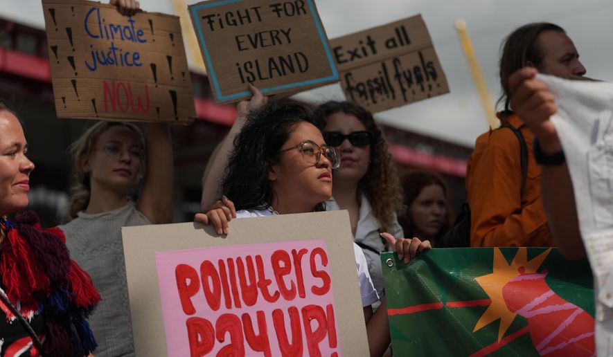 ADDS NAME - Rachelle Junsay, center, stands with other activists participating in a youth climate demonstration during the COP30 U.N. Climate Summit, Friday, Nov. 14, 2025, in Belem, Brazil. (AP Photo/Joshua A. Bickel)