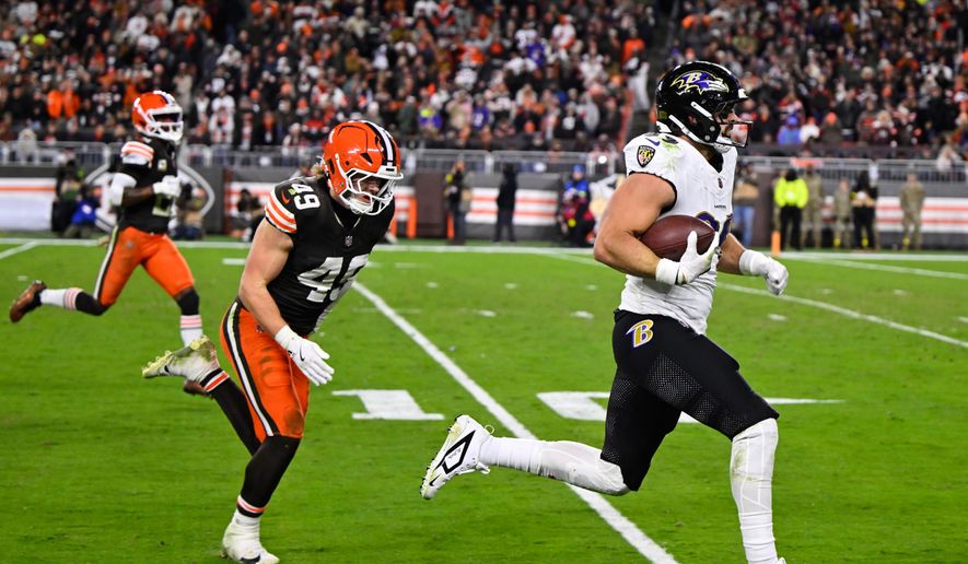 Baltimore Ravens tight end Mark Andrews (89) runs the ball for a touchdown as Cleveland Browns' Carson Schwesinger (49) gives chase in the second half of an NFL football game in Cleveland, Sunday, Nov. 16, 2025. (AP Photo/David Richard)