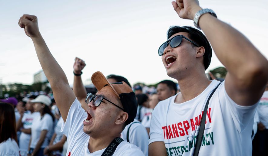 Members of the religious sect Iglesia Ni Cristo (Church of Christ) shout slogans during a three-day anti-corruption rally at Manila's Rizal Park, Philippines on Sunday, Nov. 16, 2025. (AP Photo/Mark Cristino)