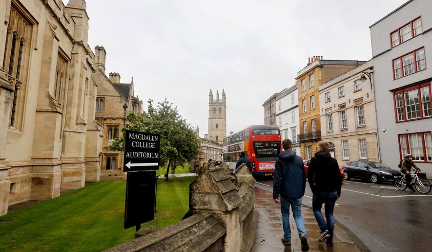 FILE - People walk around Oxford University's campus on Sept. 3, 2017, in Oxford, England. (AP Photo/Caroline Spiezio, File)