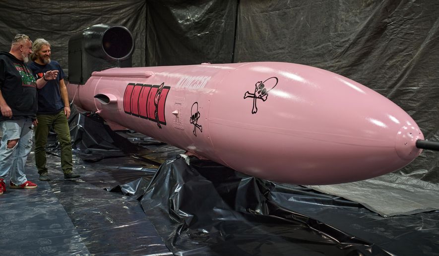 Jan Polak, right, and Martin Ondracek from the Czech organization, Weapons to Ukraine, look at a Flamingo cruise missile which was paid for by their crowdfunding campaign, at the Fire Point factory at an undisclosed location in Ukraine, Sunday, Nov. 16, 2025. (AP Photo/Efrem Lukatsky)