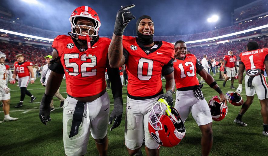 Georgia defensive lineman Christen Miller (52) and linebacker Gabe Harris Jr. (0) react after an NCAA college football game against Texas, Saturday, Nov. 15, 2025, in Athens, Ga. (AP Photo/Colin Hubbard)