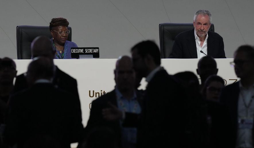 People come and go from a plenary session as André Corrêa do Lago, COP30 president, sits at back right, during the COP30 U.N. Climate Summit, Monday, Nov. 17, 2025, in Belem, Brazil. (AP Photo/Fernando Llano)