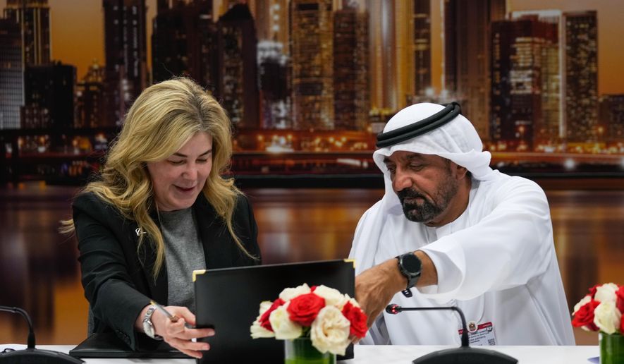 Stephanie Pope, President and CEO of Boeing Commercial Airplanes, left, and Sheikh Ahmed bin Saeed Al Maktoum, President, Dubai Civil Aviation Authority and Chairman of Emirates airlines, sign an agreement to order 65 additional Boeing 777X aircrafts during a press conference on the opening day of the Dubai Air Show, United Arab Emirates, Monday, Nov. 17, 2025. (AP Photo/Altaf Qadri)