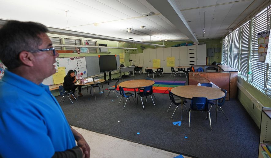 Principal Fernando Hernandez looks on in an empty classroom where a teacher is taking a lunch break at Perkins K-8 School Thursday, Nov. 13, 2025, in San Diego. (AP Photo/Gregory Bull)