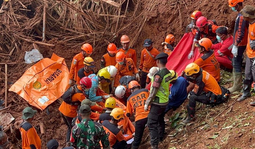 In this photo released by the Indonesian National Search and Rescue Agency (BASARNAS) on Monday, Nov. 17, 2025, rescuers recover a victim of a landslide in Cilacap, Indonesia. (BASARNAS via AP)