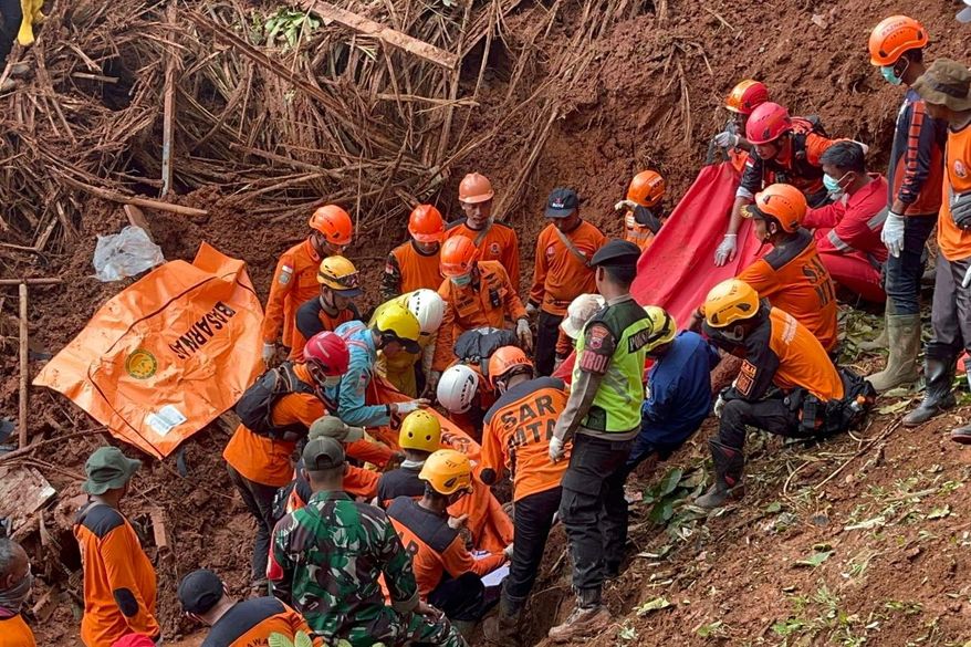 In this photo released by the Indonesian National Search and Rescue Agency (BASARNAS) on Monday, Nov. 17, 2025, rescuers recover a victim of a landslide in Cilacap, Indonesia. (BASARNAS via AP)