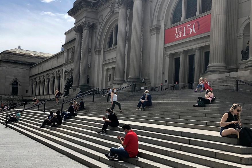 FILE - People sit outside the Metropolitan Museum of Art on May 2, 2020 in New York. (AP Photo/Ron Blum, file)