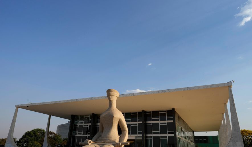 FILE - The Statue of Justice stands in front of the Supreme Court during the verdict and sentencing phase of a trial for those charged in an alleged coup plot to keep Brazil's former President Jair Bolsonaro in office after his 2022 election defeat, in Brasilia, Brazil, Sept. 11, 2025. (AP Photo/Eraldo Peres, File)