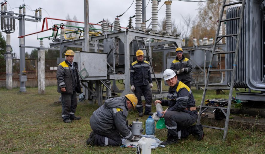 CORRECTS FAMILY NAME TO ADAMCHUK - Oleksandr Adamchuk, 36, a repair and maintenance master for DTEK, second from right, does scheduled repair work on an energy substation with his brigade, from left, Rostyslav Yashchuk, Roman Gerasymchuk, Andriy Korniychuk and Igor Kryvenko, Friday, Oct. 24, 2025, in Kyiv region, Ukraine. (AP Photo/Julia Demaree Nikhinson)