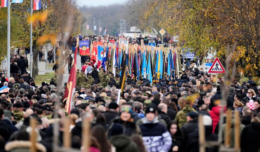 A procession makes its way towards the cemetery commemorating the anniversary of the town's fall during the 1991-95 war when it was practically demolished by Serb-led Yugoslav army troops following an 87-day siege, in Vukovar, eastern Croatia, Tuesday, Nov. 18, 2025. (AP Photo/Darko Bandic)