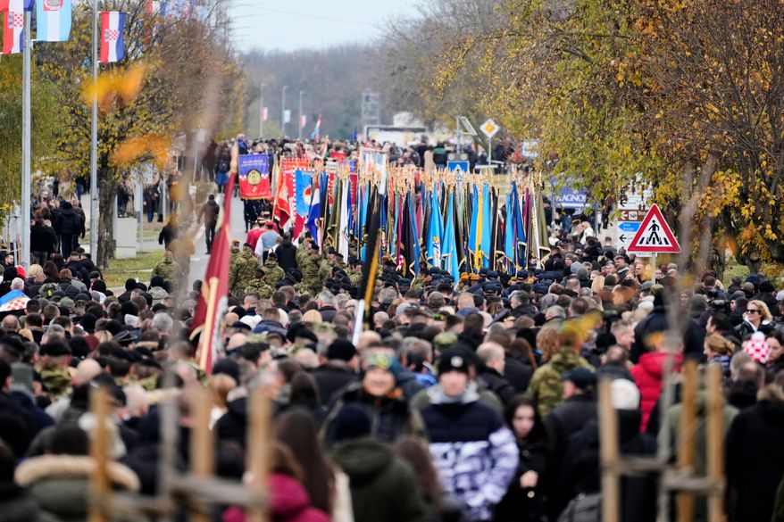 A procession makes its way towards the cemetery commemorating the anniversary of the town's fall during the 1991-95 war when it was practically demolished by Serb-led Yugoslav army troops following an 87-day siege, in Vukovar, eastern Croatia, Tuesday, Nov. 18, 2025. (AP Photo/Darko Bandic)