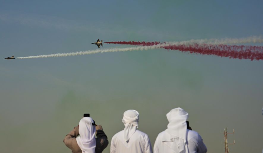 Emirati men take photos of Fursan Al Emarat, the aerobatics demonstration team of the United Arab Emirates Air Force during the Dubai Air Show in Dubai, United Arab Emirates, Tuesday, Nov. 18, 2025. (AP Photo/Fatima Shbair)