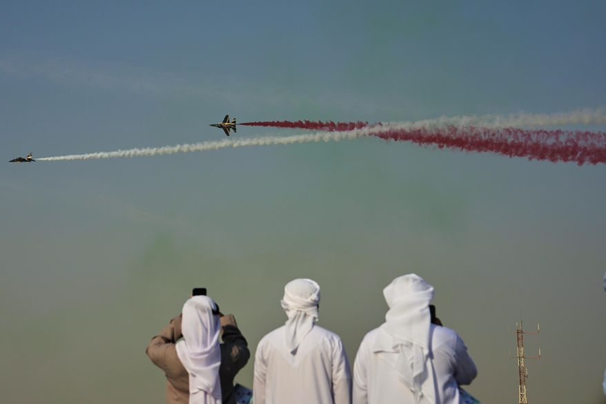 Emirati men take photos of Fursan Al Emarat, the aerobatics demonstration team of the United Arab Emirates Air Force during the Dubai Air Show in Dubai, United Arab Emirates, Tuesday, Nov. 18, 2025. (AP Photo/Fatima Shbair)