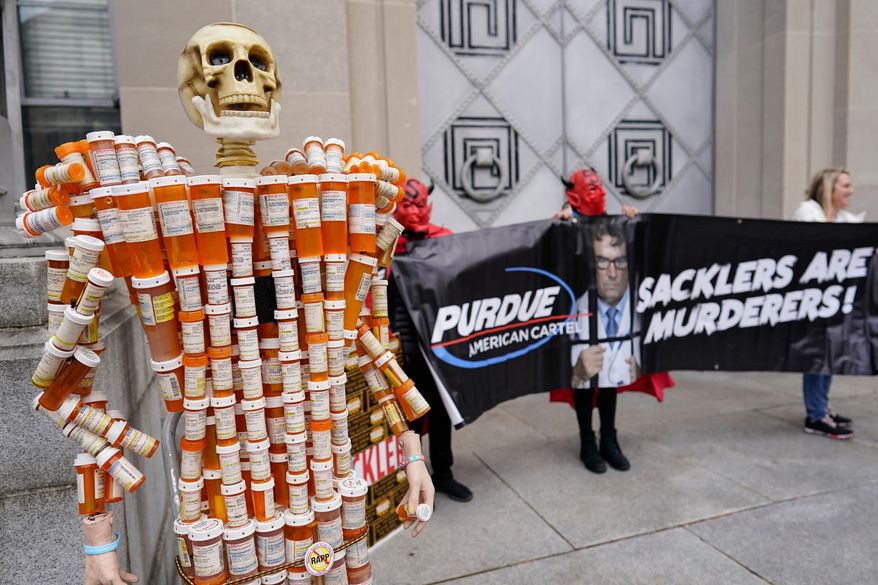 FILE - "Pill Man" made by Frank Huntley of Worcester, Mass., from his opioid prescription pill bottles, is displayed during a protest by advocates for opioid victims outside the Department of Justice, Dec. 3, 2021, in Washington. (AP Photo/Carolyn Kaster, File)