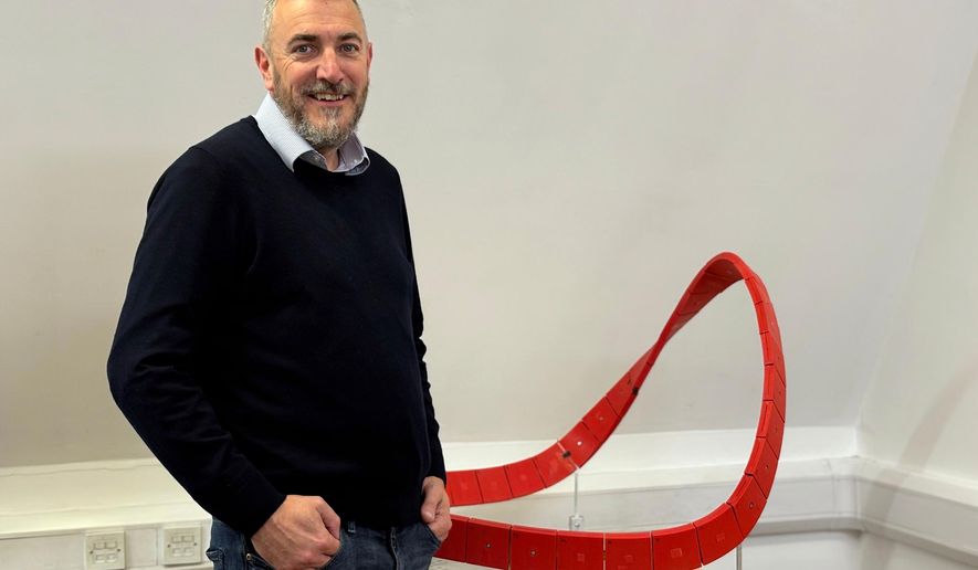 Richard Gamble, who said God spoke to him and gave him a vision for Eternal Wall of Answered Prayer in 2004, stands beside a model of the monument, Wednesday, Nov. 12, 2025, at his office in Coleshill, England. (Yonat Shimron/Religion News Service via AP)