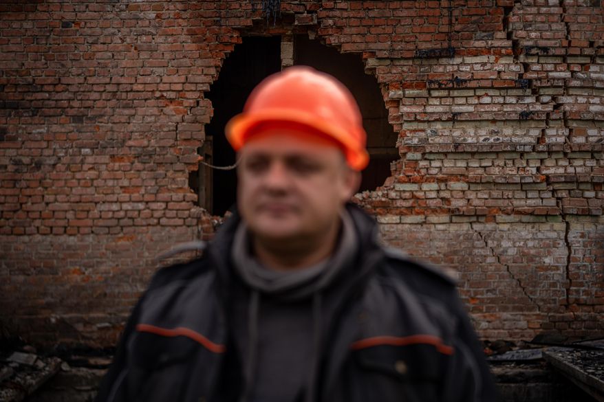 Yaroslav Brailovskyi, 43, an energy worker for Chernihiv Oblenergo, poses for a portrait in front of a substation wall damaged following a recent Russian attack, Friday, Oct. 17, 2025, in Chernihiv, Ukraine. (AP Photo/Julia Demaree Nikhinson)