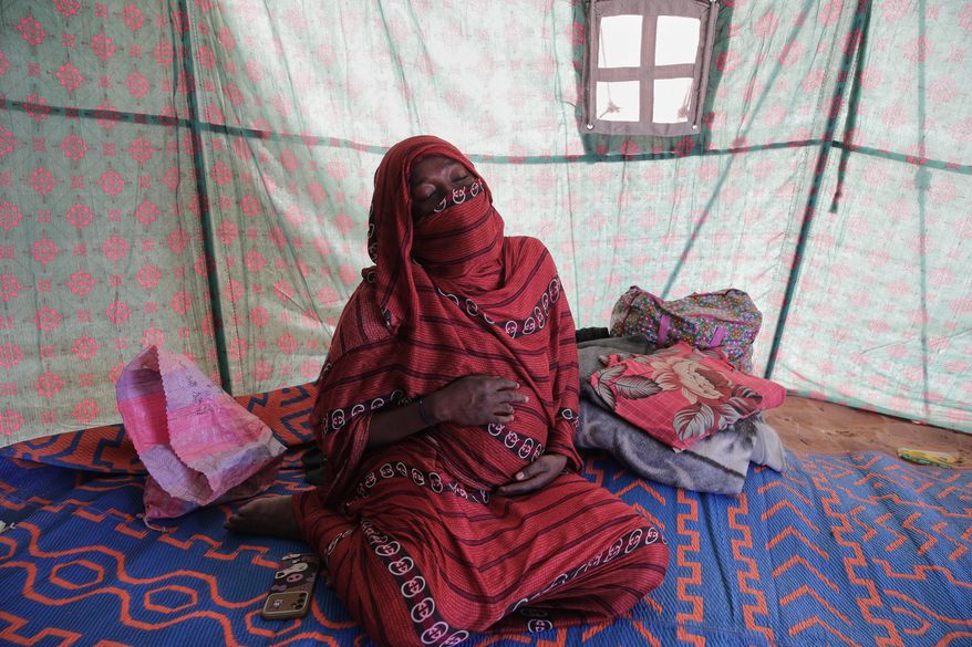 Nadra Mohamed Ahmed, 21, reacts during an interview with The Associated Press inside her tent at the newly established El-Afadh camp in Al Dabbah, Sudan's northern state, Monday, Nov. 17, 2025. (AP Photo/Marwan Ali)