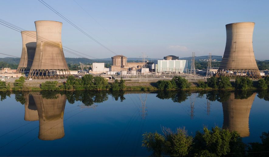 At Constellation's nuclear power plant on Three Mile Island, called the Crane Clean Energy Center, near Middletown, Pa., the cooling towers are reflected in the Susquehanna River at sunrise, June 25, 2025. (AP Photo/Ted Shaffrey, File)