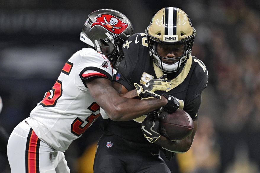 New Orleans Saints wide receiver Brandin Cooks (10) is stopped by Tampa Bay Buccaneers cornerback Jamel Dean (35) after a reception during the second half of an NFL football game Sunday, Oct. 26, 2025, in New Orleans. (AP Photo/Ella Hall)