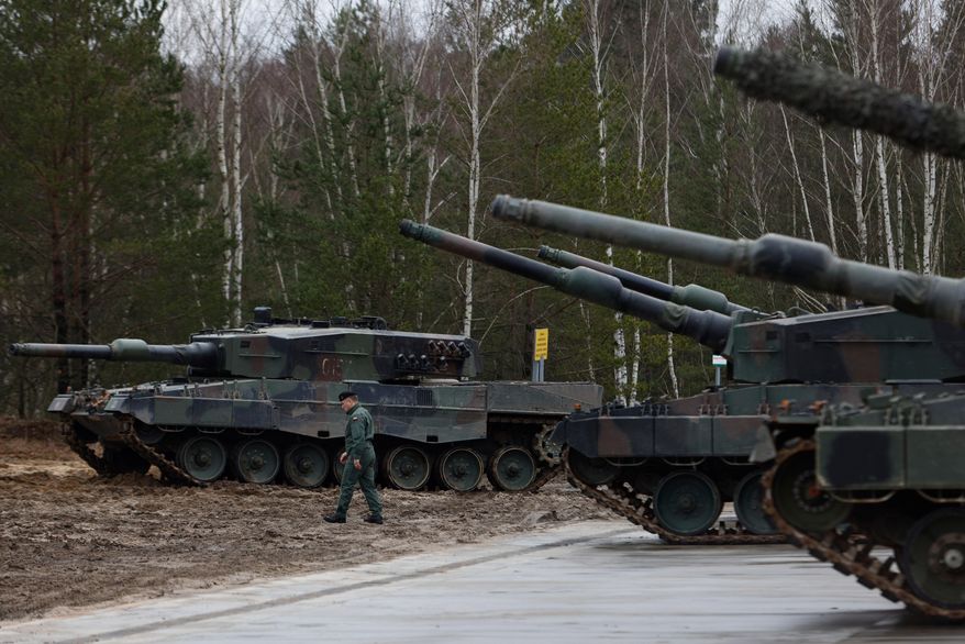 A Polish soldier walks next to the Leopard 2 tanks during a training at a military base and test range in Swietoszow, Poland, Monday, Feb. 13, 2023. (AP Photo/Michal Dyjuk, File)