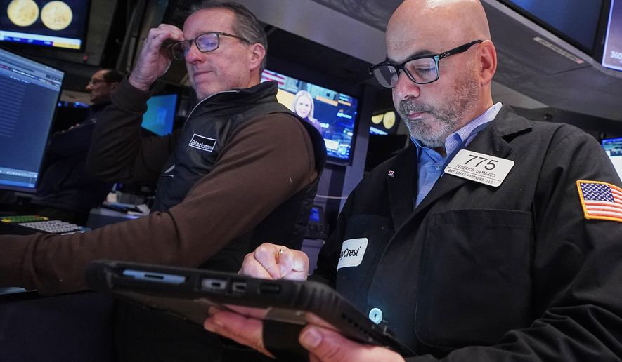Specialist Glenn Carell, left, and trader Fred Demarco work on the floor of the New York Stock Exchange, Tuesday, Nov. 18, 2025. (AP Photo/Richard Drew)