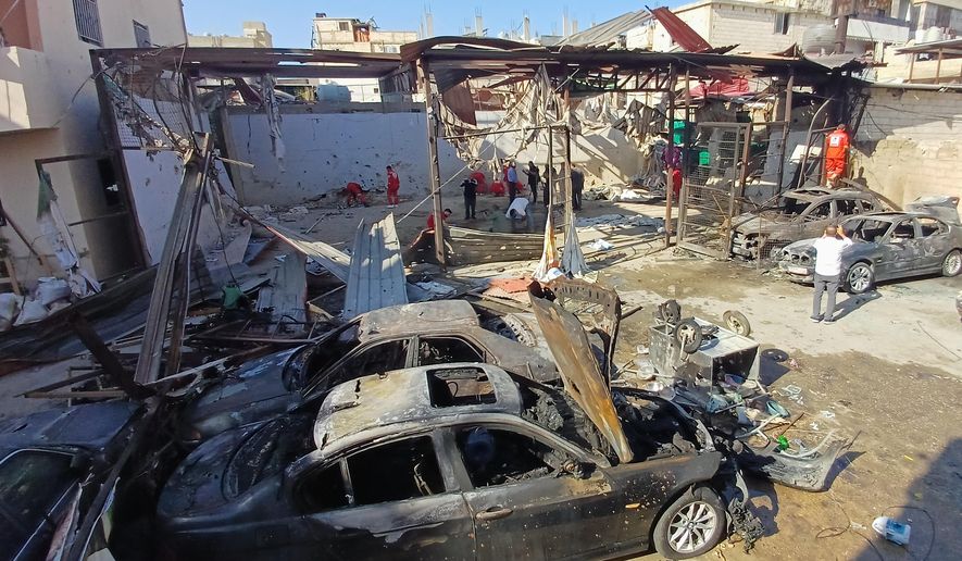 Palestinian rescue workers check the scene where an Israeli strike on Tuesday night hit the Ein el-Hilweh Palestinian refugee camp, in the southern port city of Sidon, Lebanon, Wednesday, Nov. 19, 2025. (AP Photo/Mohammed Zaatari)