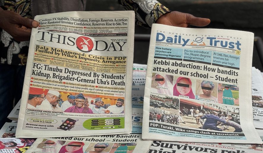 A vendor display local newspapers on the street of Lagos with headlines of the Government Girls Comprehensive Secondary School, where gunmen on Monday attacked the school dormitory, abducted schoolgirls, in Kebbi Nigeria, Wednesday, Nov. 19 2025. (AP Photo/Sunday Alamba )