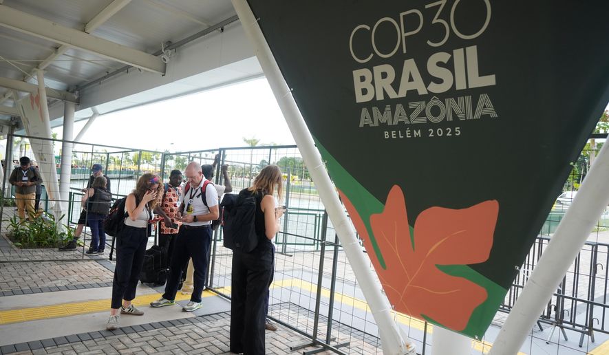 Attendees stand outside the venue for the COP30 U.N. Climate Summit after they were asked to leave, Thursday, Nov. 20, 2025, in Belem, Brazil. (AP Photo/Fernando Llano)