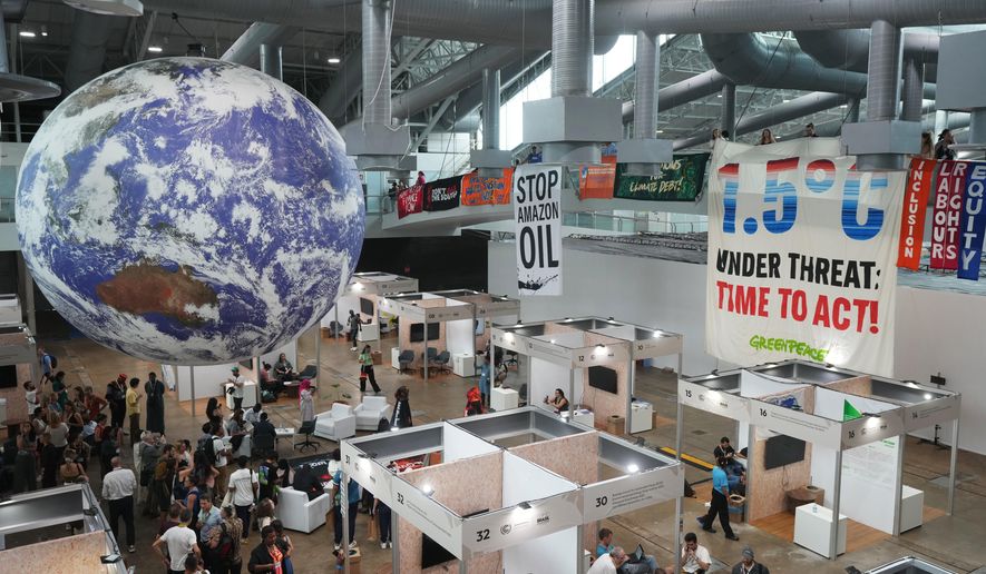 Activists hang banners while participating in a demonstration at the COP30 U.N. Climate Summit, Friday, Nov. 21, 2025, in Belem, Brazil. (AP Photo/Andre Penner)