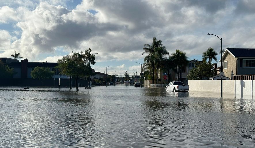 A local pond overflows into a residential neighborhood in Huntington Beach, Calif. following a storm on Friday, Nov. 21, 2025. (AP Photo/Amy Taxin)
