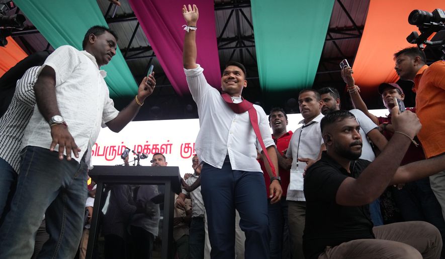 Sri Lankan lawmaker Namal Rajapaksa, heir to the once-powerful Rajapaksa dynasty, waves to supporters during a public rally in Colombo, Sri Lanka, Friday, Nov. 21, 2025. (AP Photo/Eranga Jayawardena)