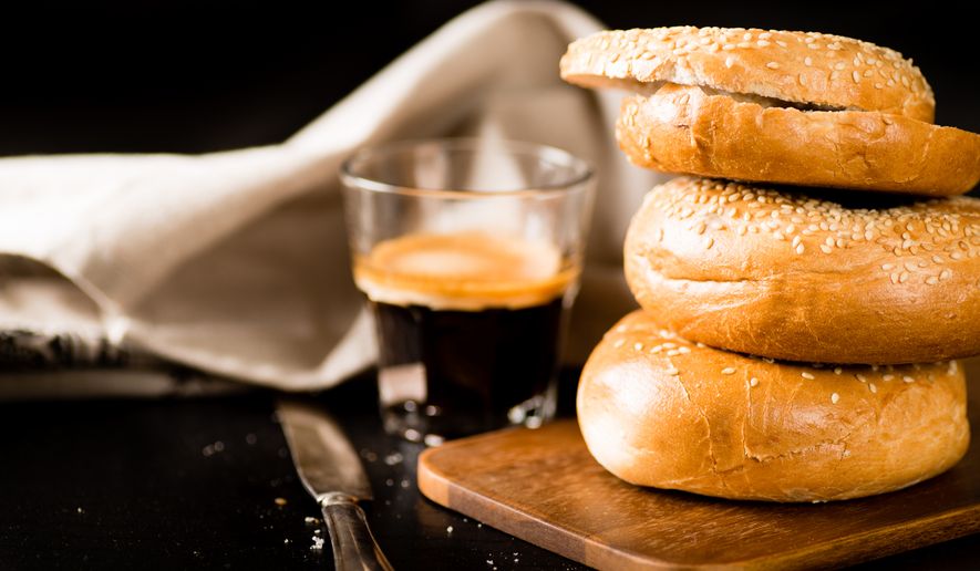 Stack of bagels with coffee on dark background. File photo credit: eugena-klykova via Shutterstock.