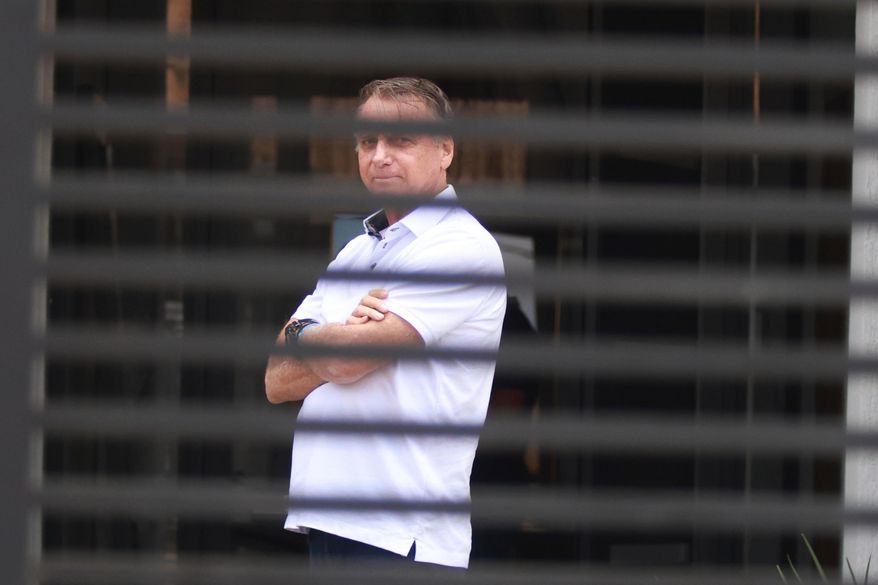 Brazil's former President Jair Bolsonaro stands at the entrance of his home where he is under house arrest in Brasilia, Brazil, Tuesday, Sept. 2, 2025. (AP Photo/Luis Nova, File)